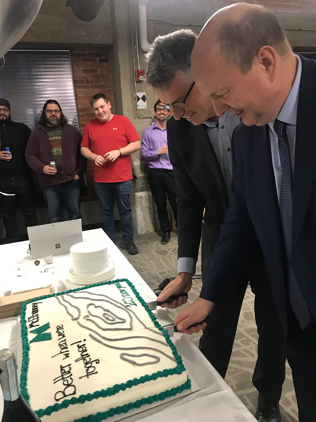 CEOs Allan Russell (left) and Bruce Winton (right) cutting the cake to celebrate