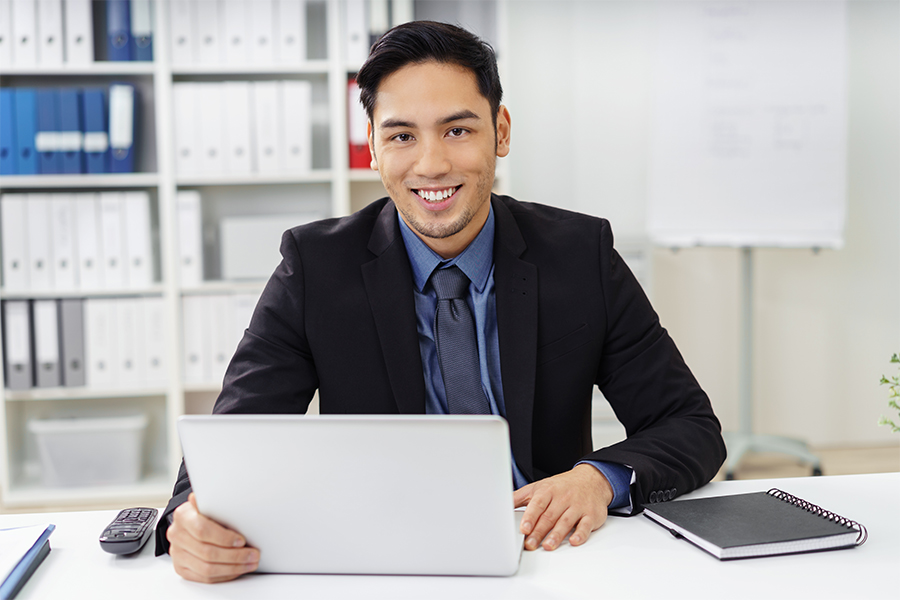 Cute,Young,Businessman,With,Goatee,Looking,Ahead,From,Behind,Laptop