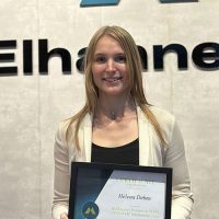 Helena holding her scholarship certificate