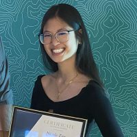 Nicole Tan holding her scholarship certificate