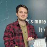 Wayne holding their scholarship certificate