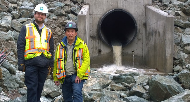 Lee Peltz, P.Eng. & Bill Cheung, P.Eng. (now retired) at the creek now flowing through their piping solution.