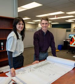 Team members reviewing project plans together in a collaborative office environment that supports intern learning and growth.
