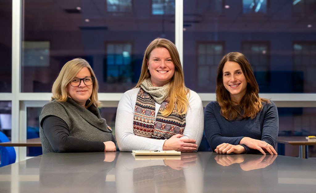 Group photo of the sustainability team outdoors with trees and greenery in the background
