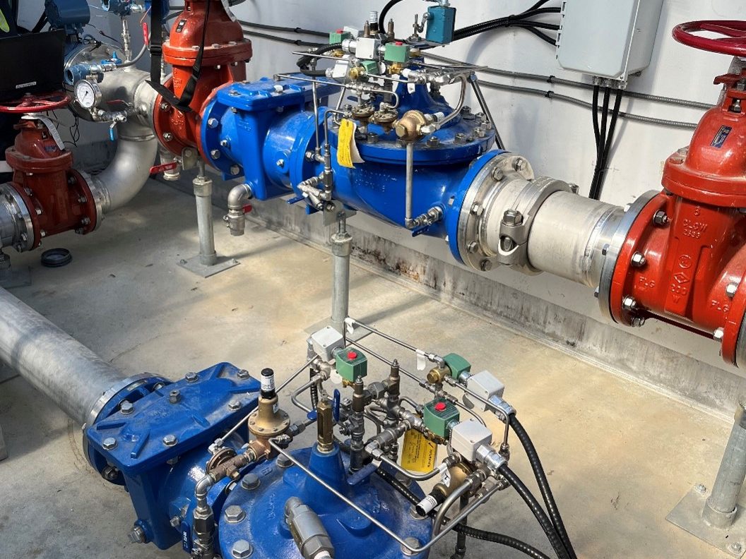 Ferrie–Quadra PRV Station Interior with Dual Pressure Reducing Valves Interior view of the Ferrie–Quadra pressure reducing valve station showing two blue PRVs with associated piping, valves, and control instrumentation during final flow meter calibration.