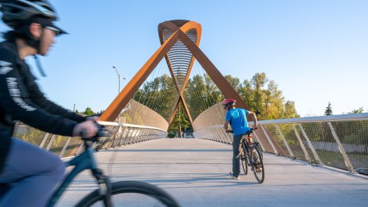 Burnaby Lake Pedestrian Bridge with two cyclists crossing in Burnaby, B.C.