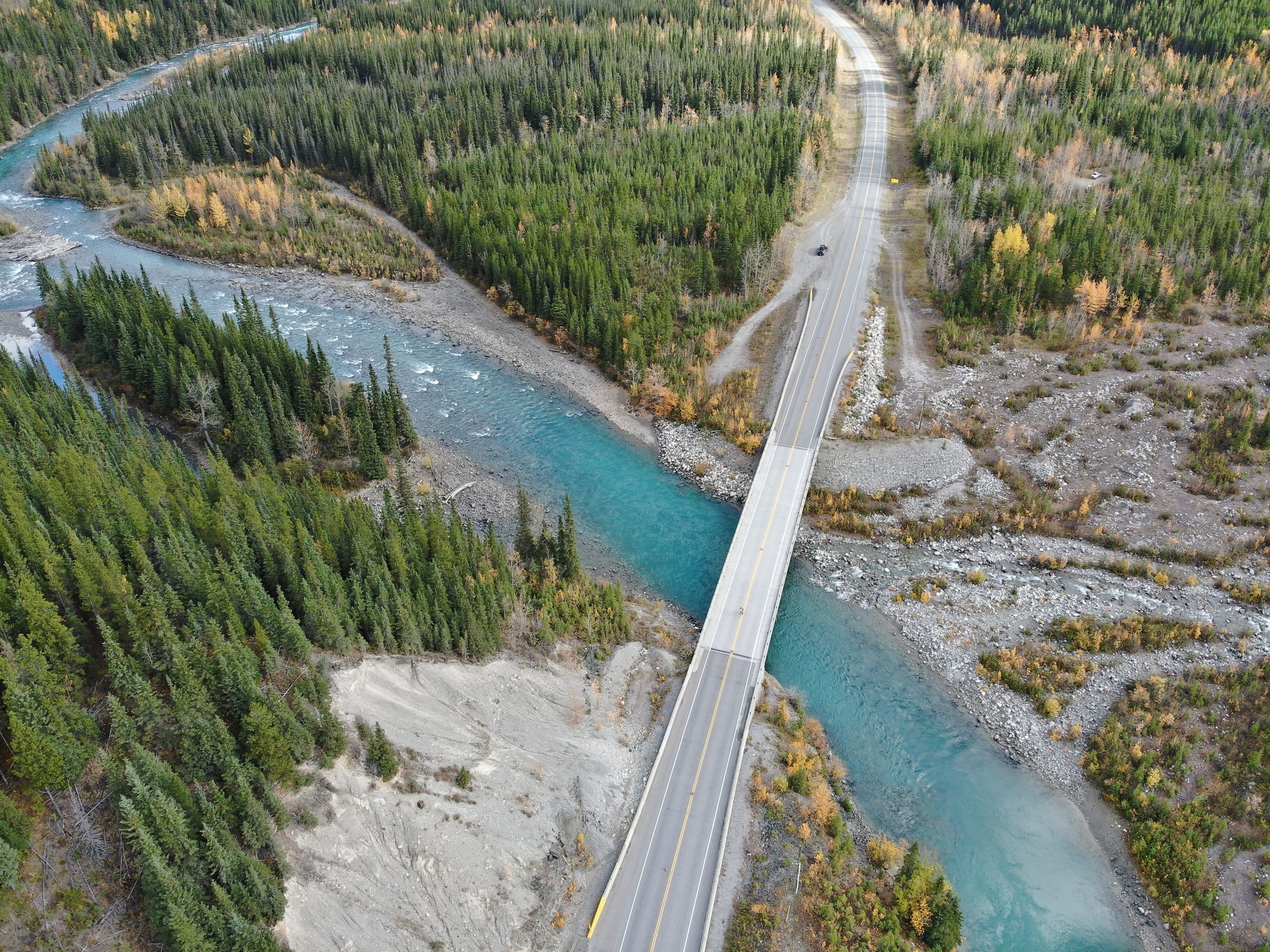 Alaska Highway Bridge Inspection and Structural Evaluation in Northern British Columbia Aerial view of a highway bridge crossing a turquoise river along the Alaska Highway corridor in northern British Columbia during a structural inspection and evaluation program.