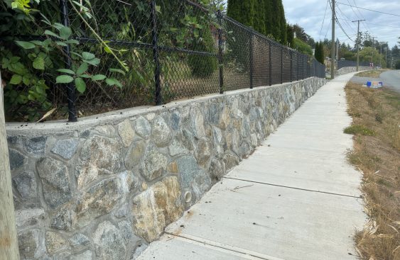 Stone retaining wall alongside a public sidewalk in Victoria, British Columbia, assessed as part of a municipal infrastructure inventory and condition assessment program.
